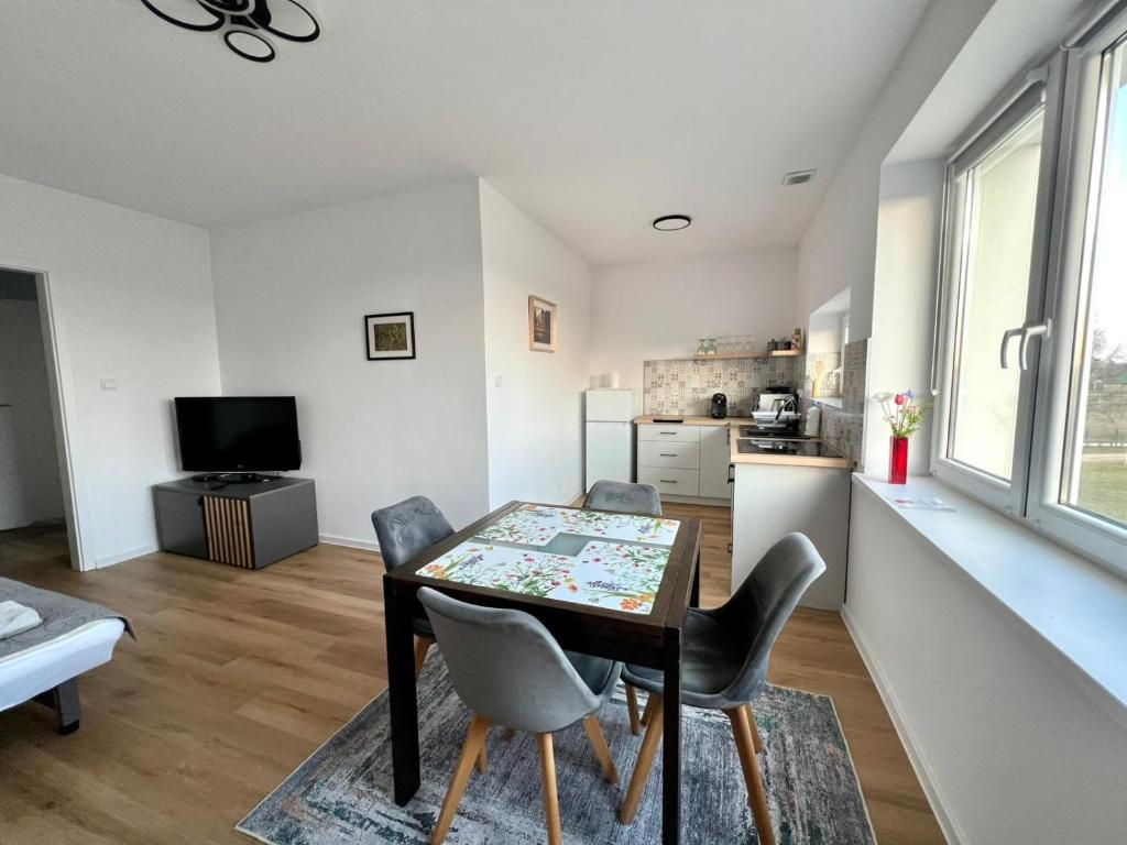 a kitchen and dining room with a table and chairs at Campus Biebrza - apartamenty biebrzańskie in Osowiec