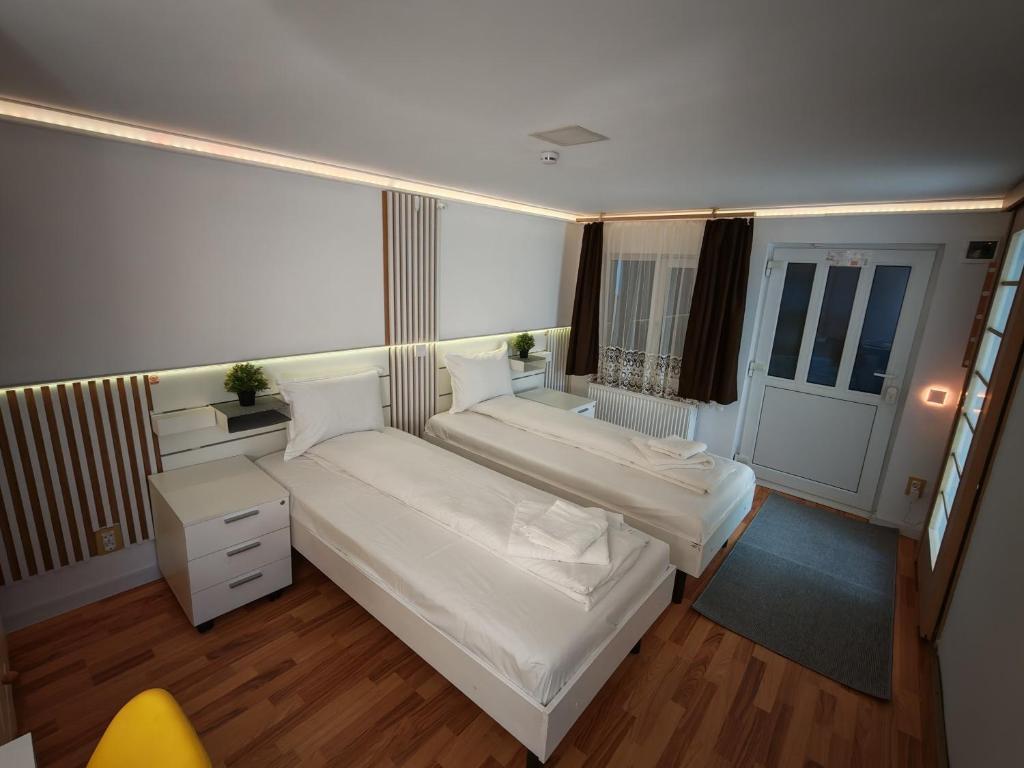 a small bedroom with two beds and a window at Sleep&Go Airport Transit Rooms Cluj-Napoca in Cluj-Napoca