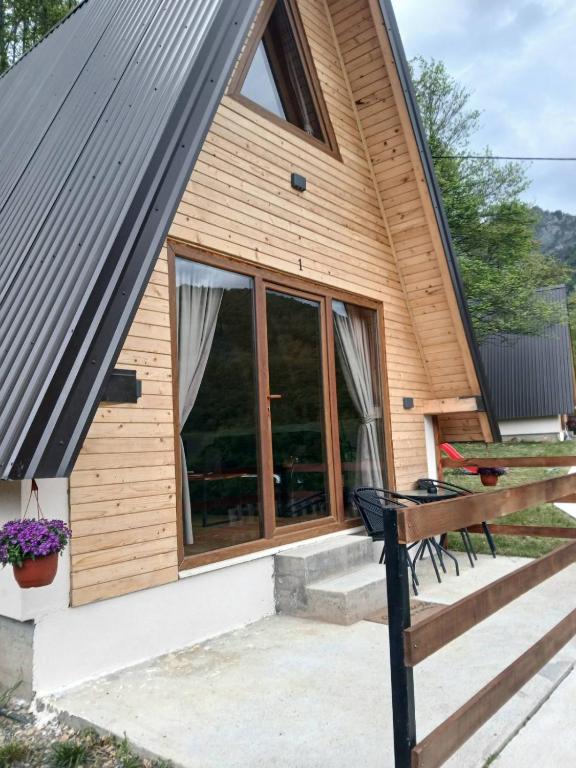 a cabin with a large window and a bench at Vikendice Limski mir in Andrijevica