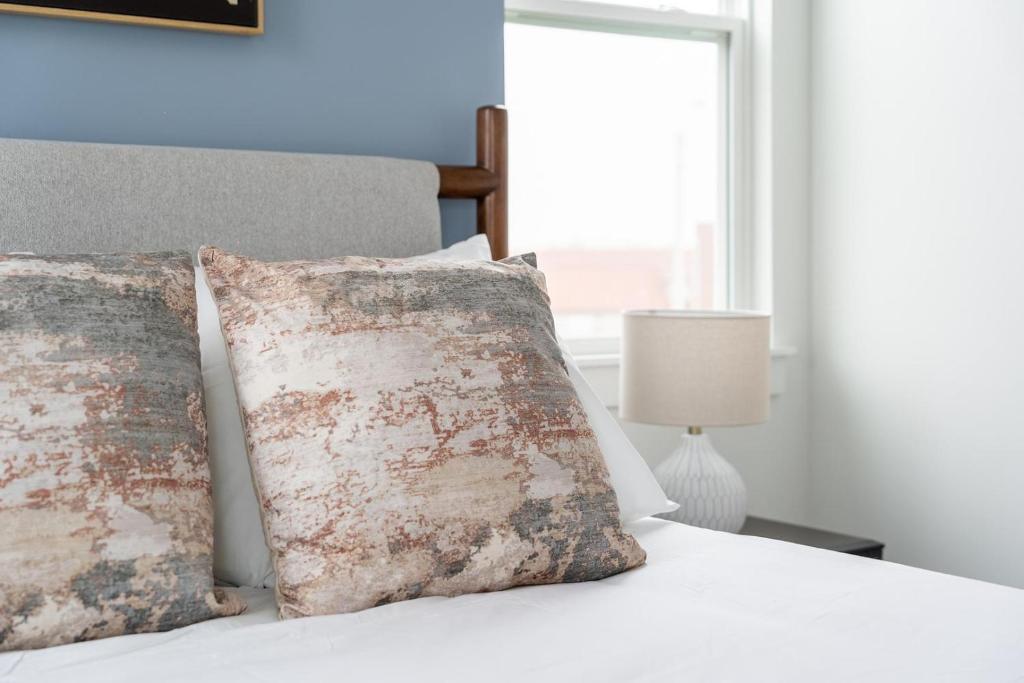 a bedroom with a bed with two pillows and a window at Landing Beautiful 2BD in Lees Summit in Lees Summit