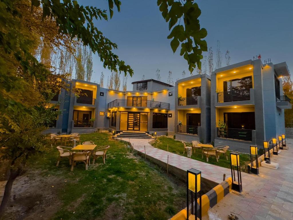 a building with tables and chairs in front of it at The Pioneer Hotel in Skardu