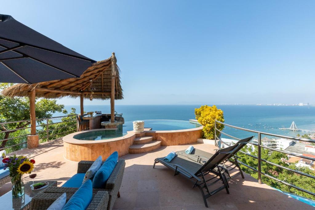 a patio with a view of the ocean at Luxe 3 King BR Villa | Infinity Pool + 220° Views in Puerto Vallarta