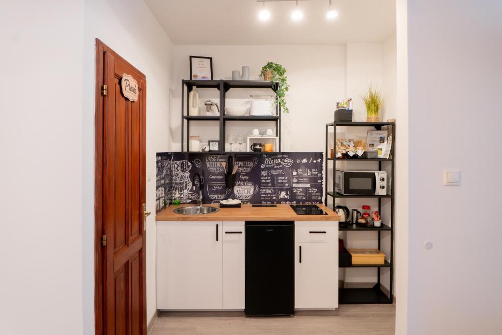a kitchen with white cabinets and a counter top at Vincellér Apartman in Villány