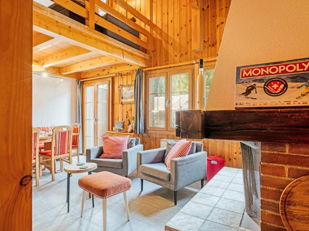 a living room with chairs and a fireplace at Chalet-Apartment mit Balkon & Gratis Parkplatz in Lenk