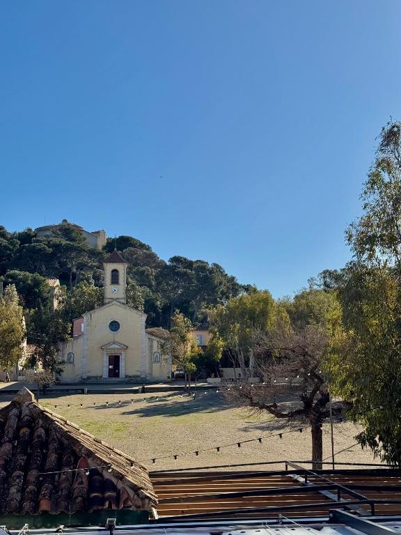 a small church with a hill in the background at L'Arche de Porquerolles in Porquerolles