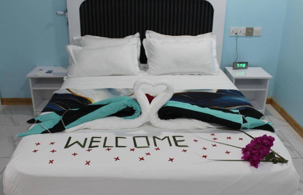 a bed with two swans in the middle at Ocean Echo Villa in Mathiveri