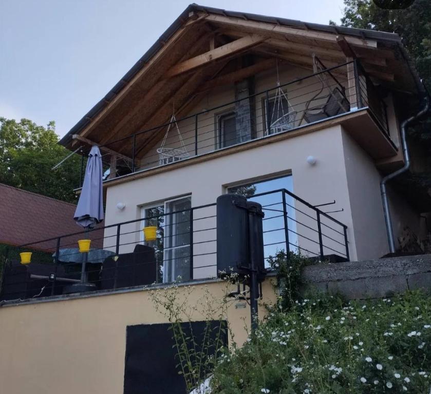 a house with a balcony with black railing at Bovan vikendica za izdavanje in Jezero
