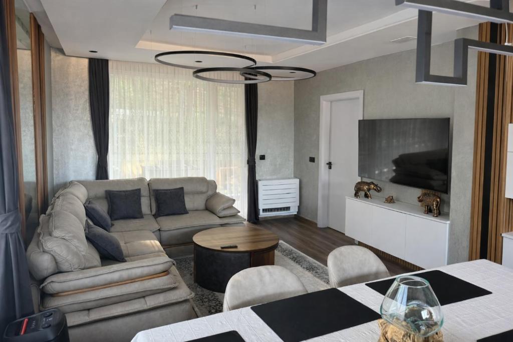 a living room with a couch and a table at Forest Panorama Luxury Apartment in Velingrad