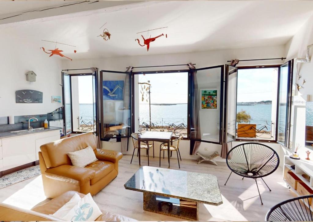 a living room with a couch and a table at Sunset lodge in Bouzigues