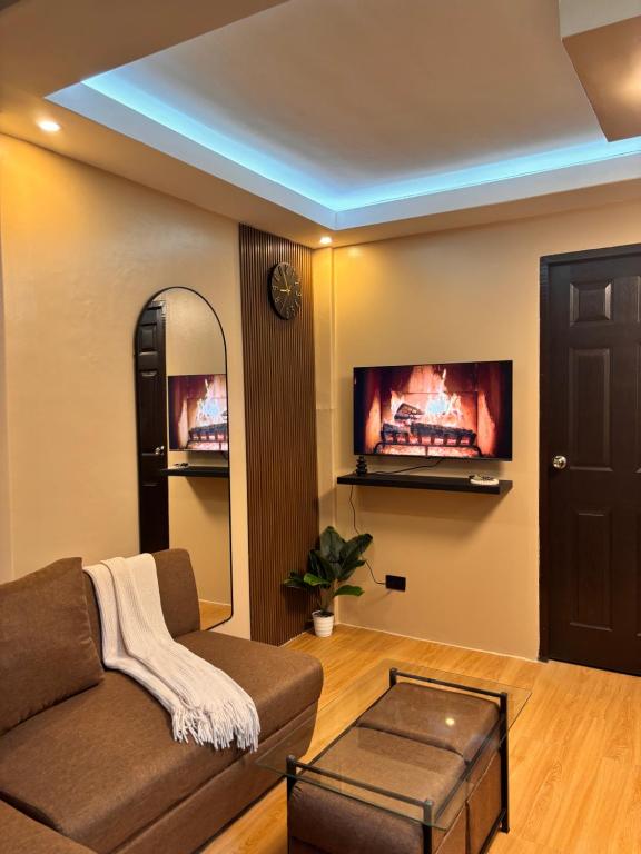 a living room with a couch and a tv on the wall at Casa Selenó in Batangas City