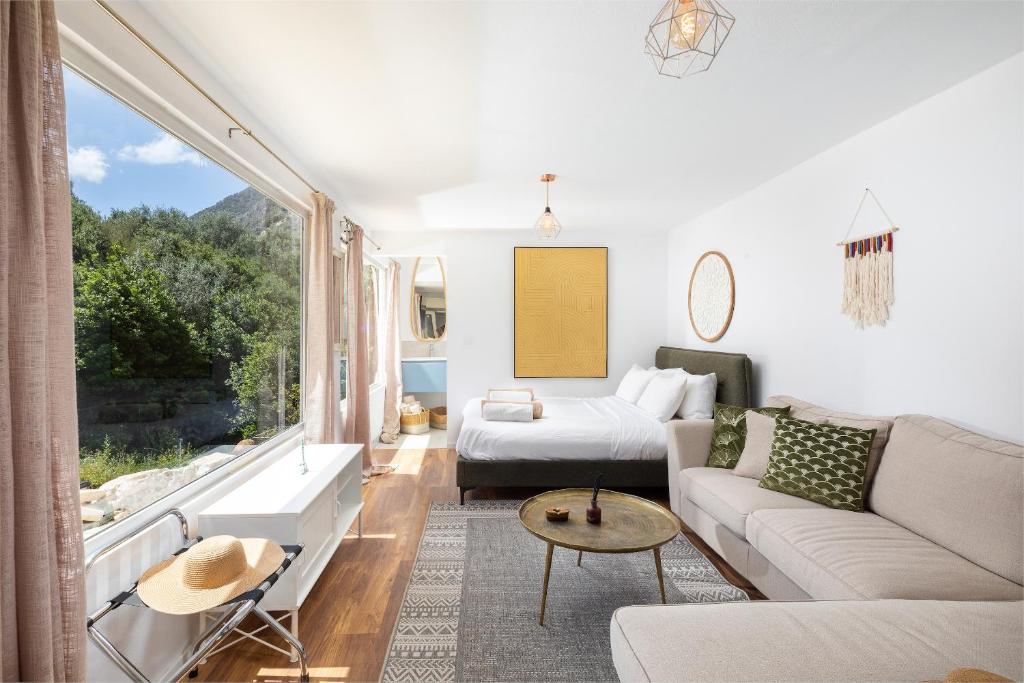 a living room with a couch and a table at Elysian by the sea in Nisaki