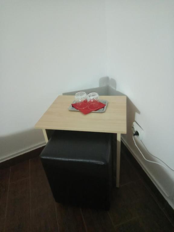 Ein Tisch mit zwei Gläsern auf einem schwarzen Hocker in der Unterkunft LaCoco in Buşteni