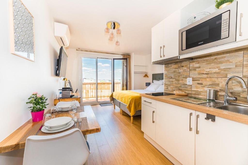 a kitchen and living room with a bed and a sink at Beausoleil Metro Paris Sud in Le Kremlin-Bicêtre