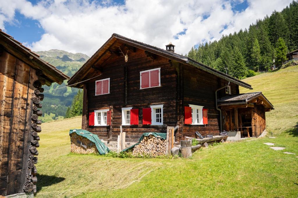 a wooden house on a hill with red shutters at  