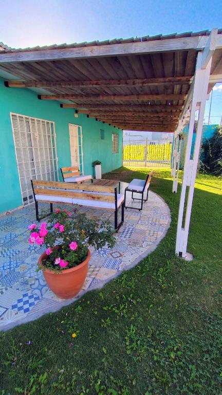 a patio with benches and flowers in a yard at La Candela in Olavarría