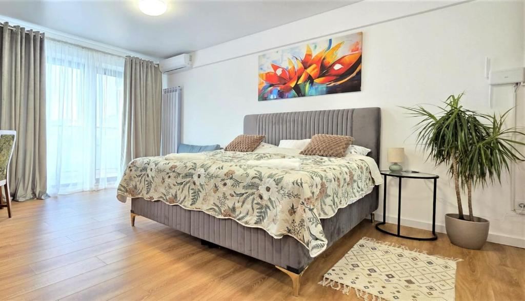 a bedroom with a bed and a painting on the wall at Mountain View Studio in Piatra Neamţ