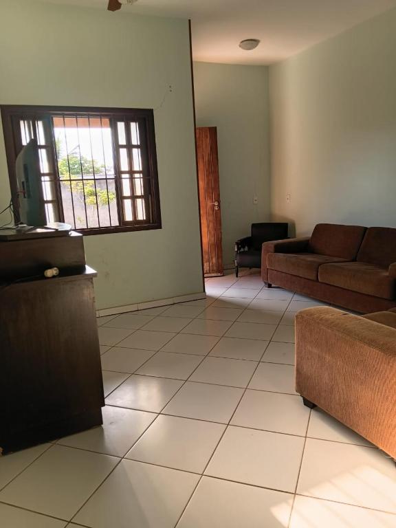 a living room with a couch and a window at Recanto Seu sossego ! in Maricá