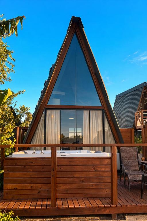 a house with a hot tub on a deck at Cabanas Farol in Pântano Grande