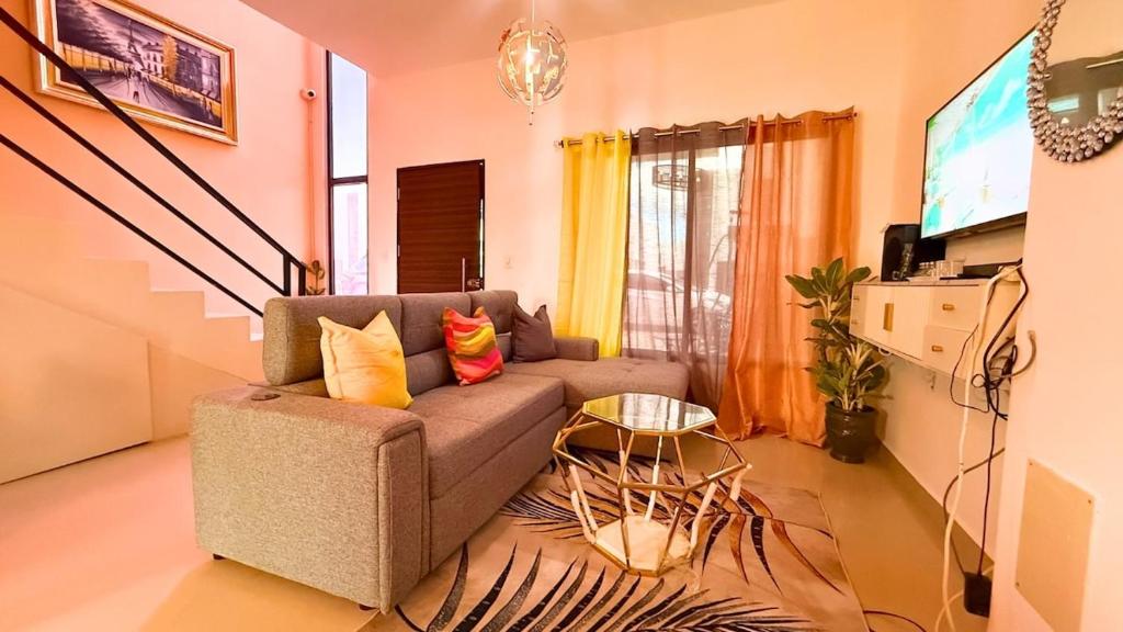 a living room with a couch and a tv at Cozy 1 bedroom in Punta Cana