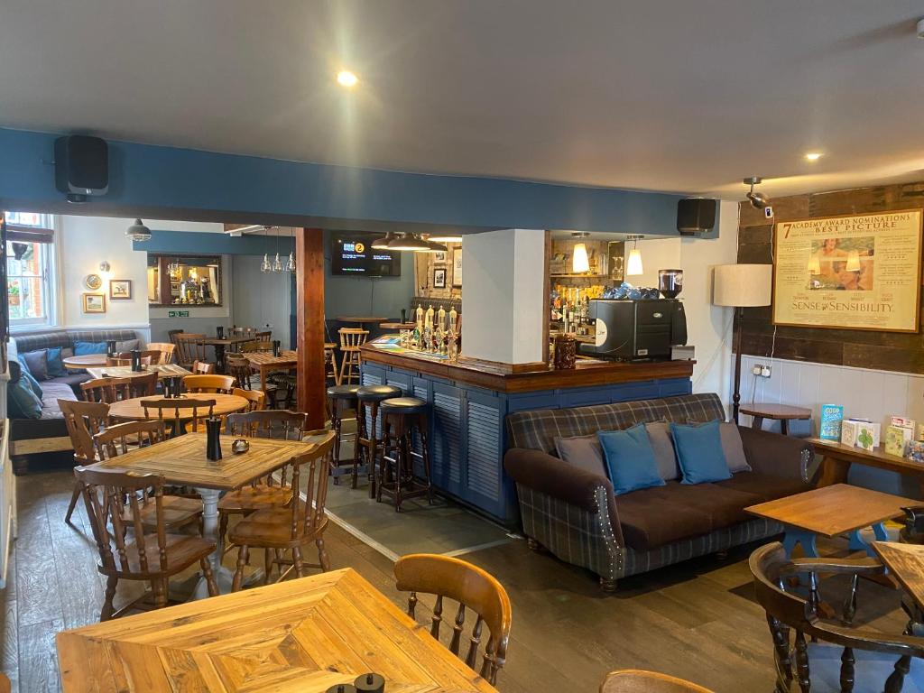 a restaurant with tables and couches and a bar at The Phelips Arms in Montacute