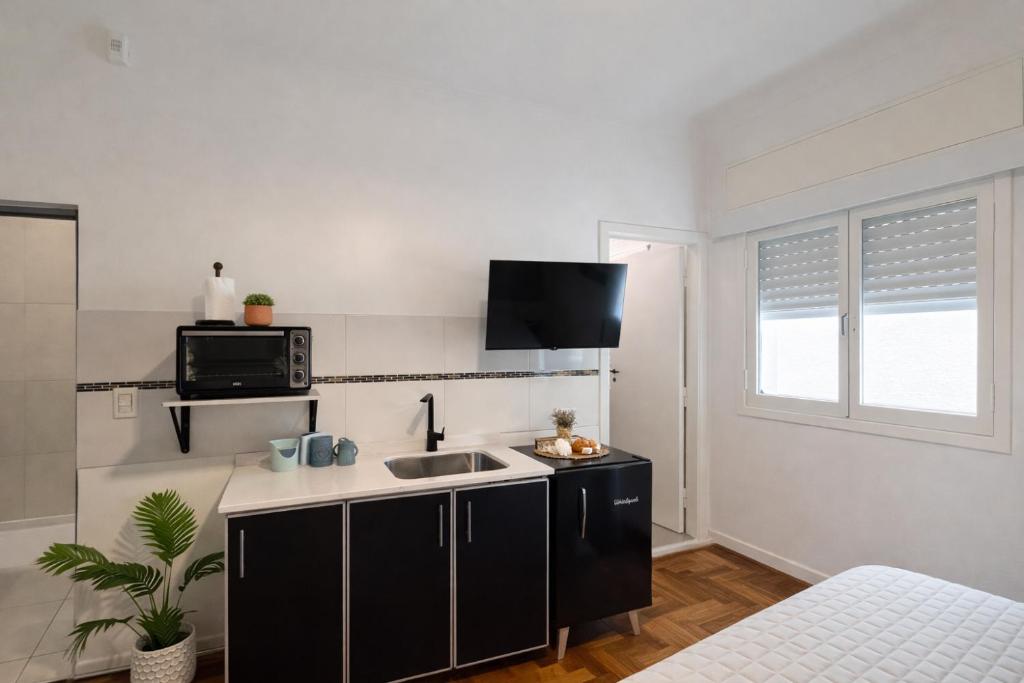 a kitchen with a sink and a microwave at Ana Rent lll Moderno departamento ,San Isidro punto medio Tigre River y Tecnopolis in Boulogne