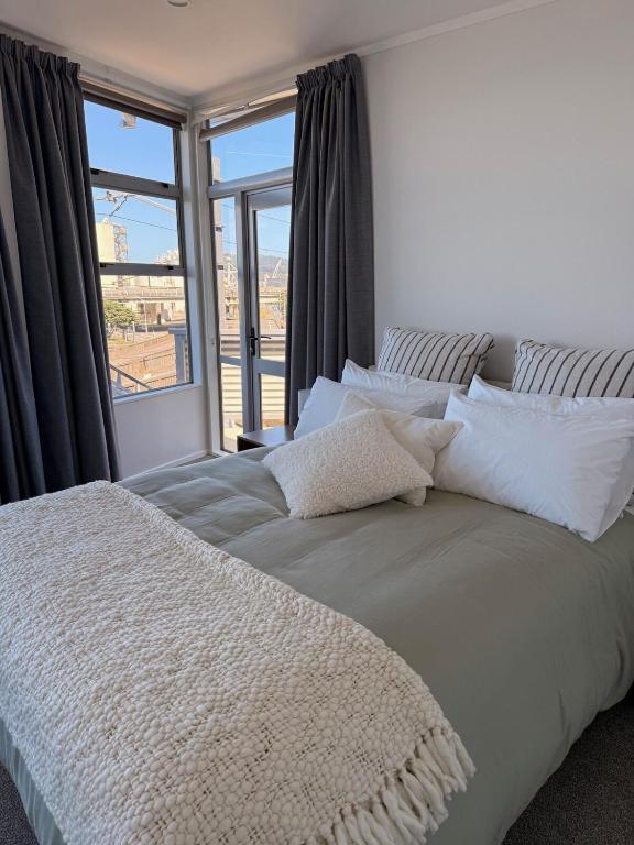 a bedroom with a bed with a large window at Stylish Private Apartment, Close to Ferry, Stadium, Parking in Wellington