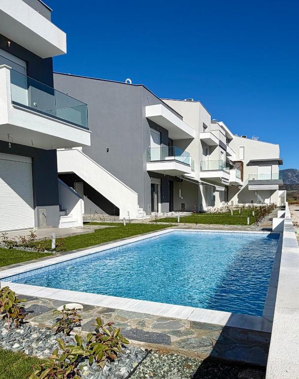 a house with a swimming pool in front of a building at Green Almond D1 in Orfánion