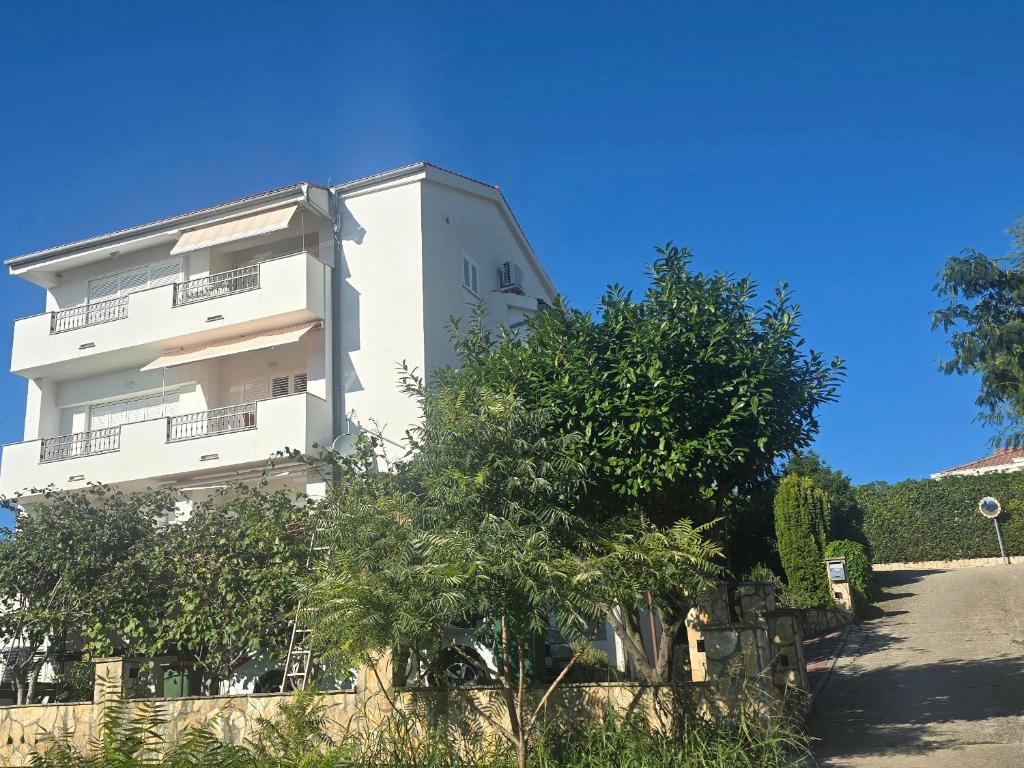 a white building with trees in front of it at Apartments Buljan in Kožino