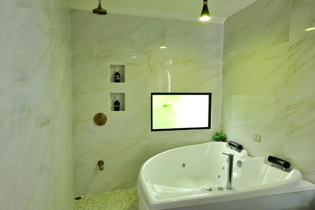 a white bathroom with a bath tub and a sink at Volcano Garden Suite with Hottub in Palma