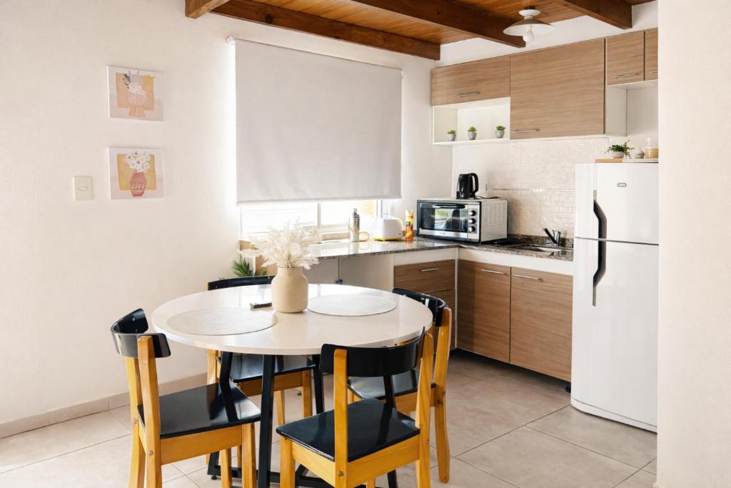 a kitchen with a table and chairs and a white refrigerator at Ana rent Ballester departamentos modernos luminosos, equipados para una hermosa estadia in Villa Ballester