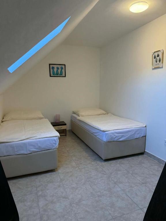 two beds in a room with a attic at Ubytovna u Maiky in Libochovice