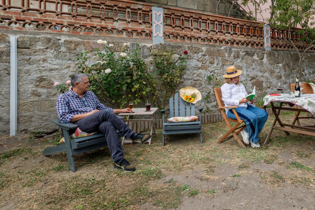 two people sitting in chairs at a table at Casa de Santa Rita in Chaves