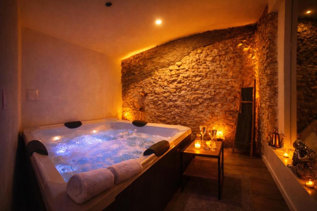 a large bath tub in a room with a stone wall at fuga romantica in Benisuera