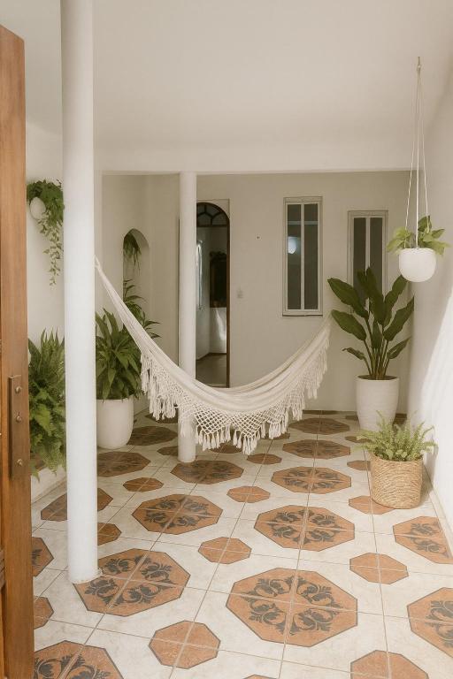 a room with a hammock and potted plants at Casa de Mainha in Salvador