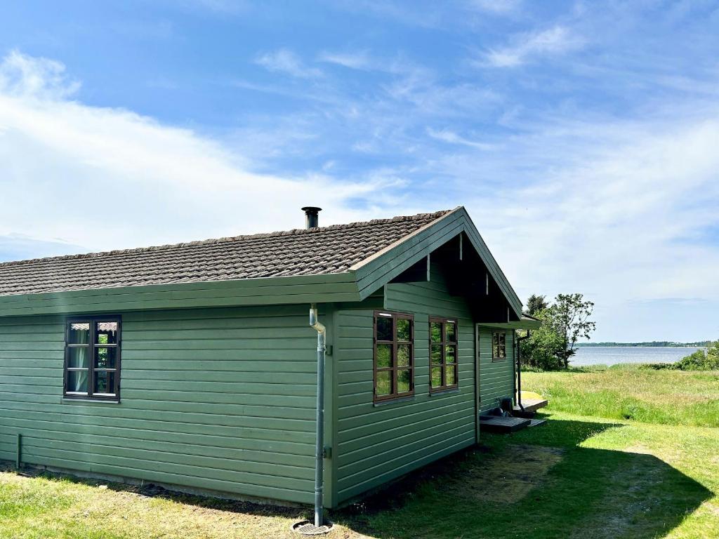 a green house sitting on top of a field at Beachclose Log Cabin On Mors With A View in Nykøbing Mors