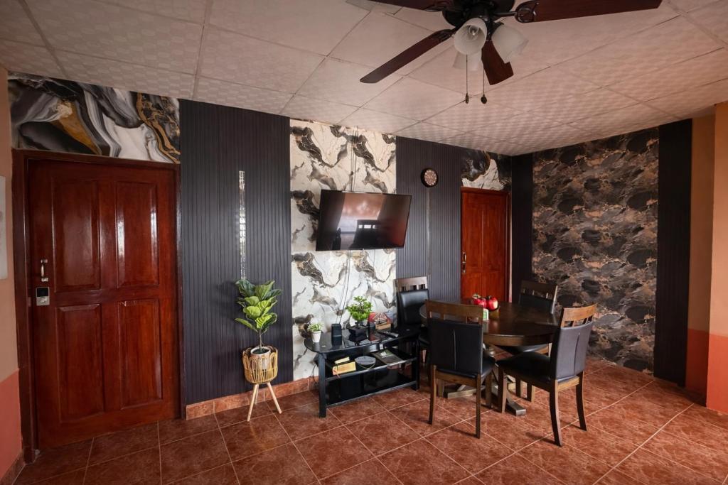 a dining room with a table and a ceiling fan at Ethlyn House in Bocas Town