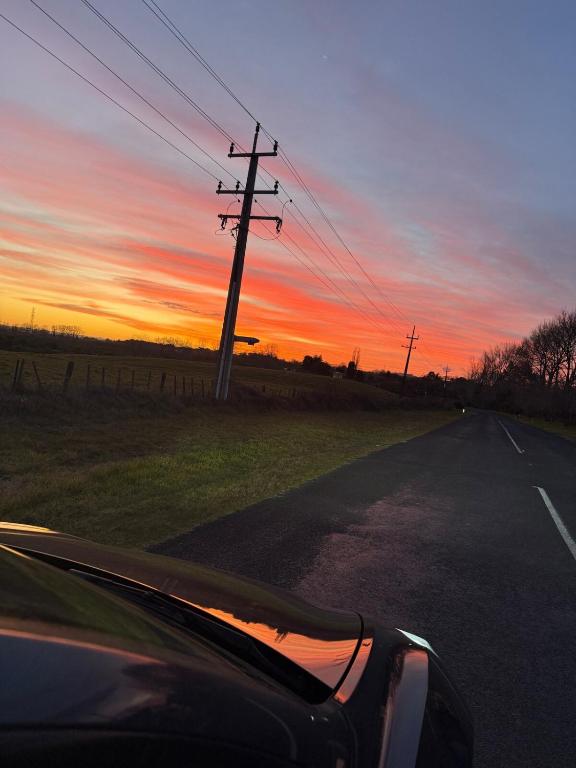 a car driving down a road at sunset at Vineyard Cabin in Te Kauwhata
