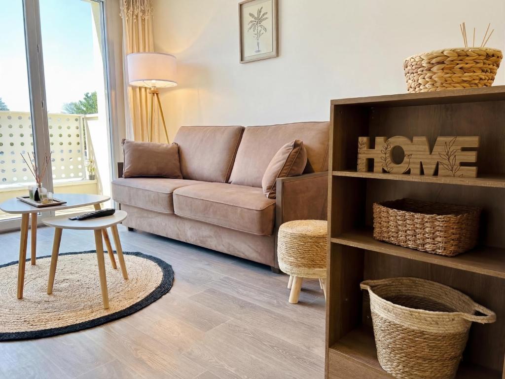 a living room with a couch and a table at Lumen Chartrain - appartement proche centre-ville, balcon et parking in Chartres