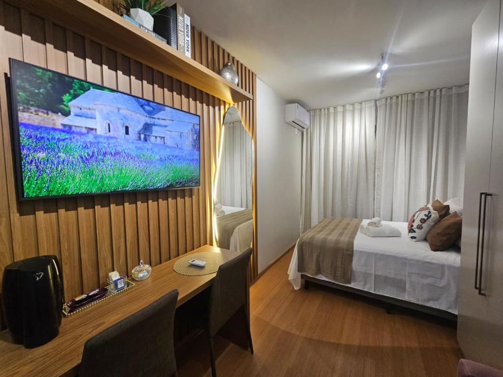 a bedroom with a bed and a tv on a wall at Studio Itaú Metrô Conceição in São Paulo