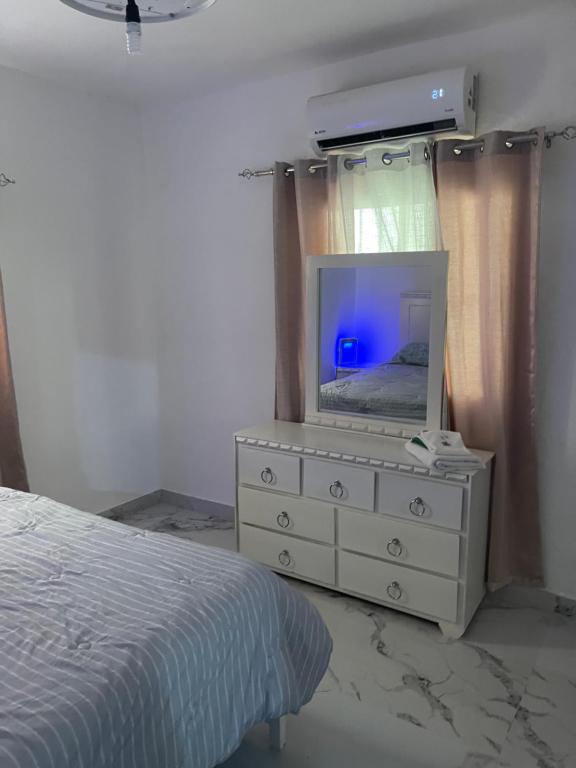 a bedroom with a dresser with a television on it at Villa Rivera in Boca Chica