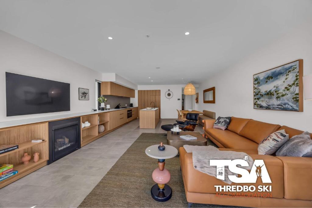 a living room with a couch and a tv at Black Bear 402 in Thredbo