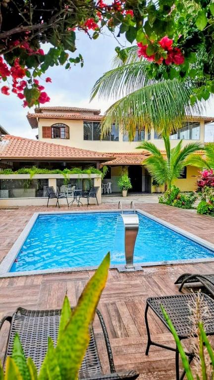 a swimming pool in front of a villa at Casa Linear Térrea com Piscina no Atlântico in Rio das Ostras