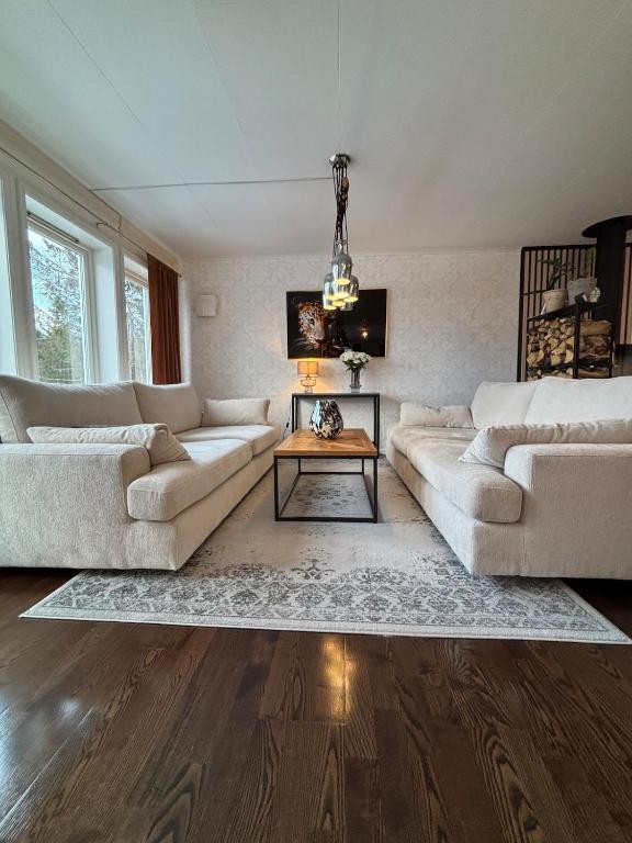 a living room with two couches and a table at Raufoss Villa Residence in Raufoss
