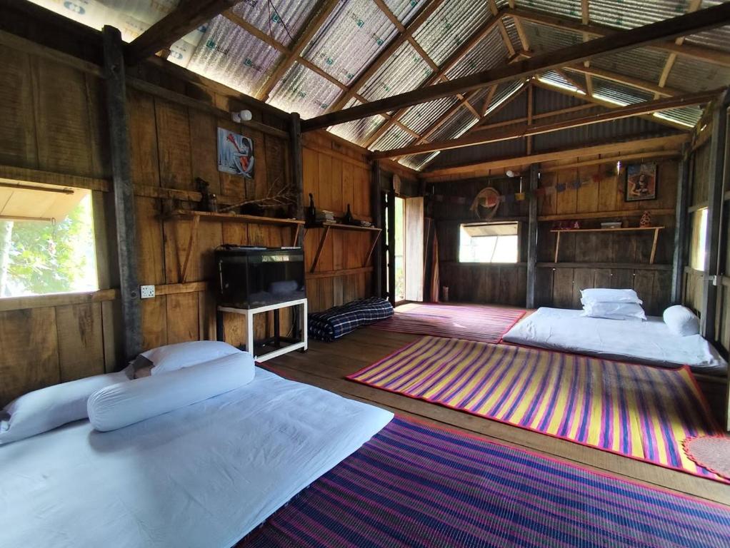 a room with two beds and a tv in it at Hijoltola Camping & Resort in Kumāran