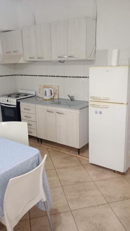 a kitchen with white cabinets and a white refrigerator at El Amuleto in Rivadavia