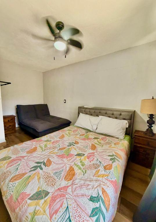 a bedroom with a bed and a ceiling fan at Alojamiento en Tambaca, Tamasopo SLP in Tambaca