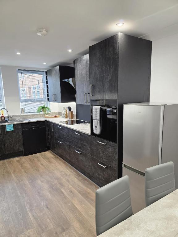a kitchen with stainless steel appliances and a refrigerator at Charming three bedroom house in Durham in Brandon