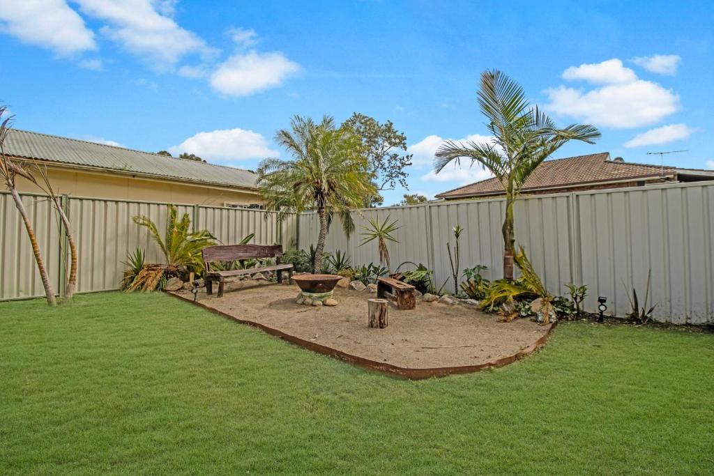 a backyard with a bench and a picnic table at Palms on Wunda in Sussex Inlet