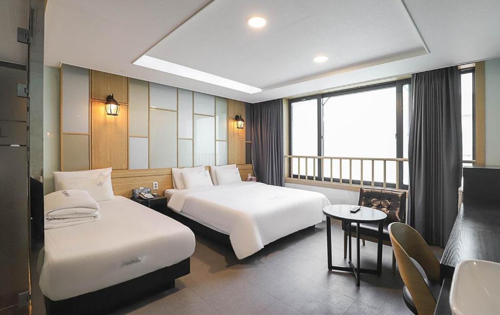 a hotel room with two beds and a table at Nampo MGM Hotel in Busan