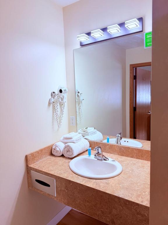 a bathroom with a sink and a large mirror at The Kingsley Suites in Kingsley